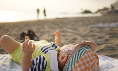海辺で寝転がる赤ん坊